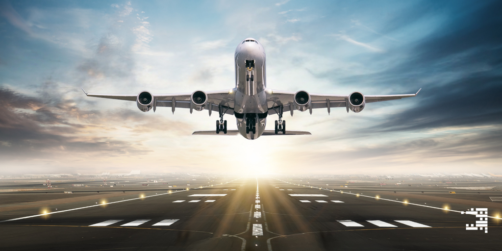 Airplane taking off from an airport runway with a bright sky in the background